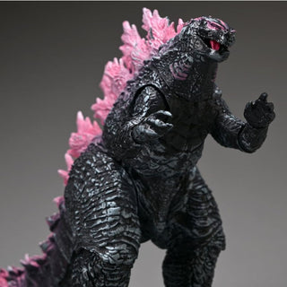 Godzilla action figure with pink spines on a gray background