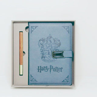 Blue notebook with Gryffindor crest and 'Harry Potter' branding, featuring a pen, in a box on a white background
