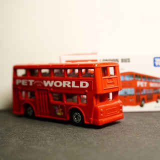 Red toy double-decker bus with 'Pet World' branding on a gray surface.