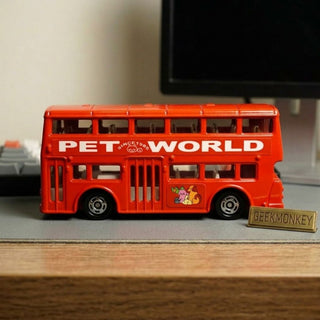 Red toy bus with 'PET WORLD' text on a desk