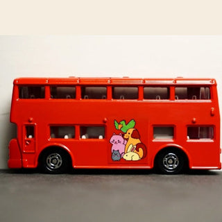 Red double-decker bus toy with cartoon characters on a gray surface