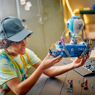 child playing with built up building block model battle bus - fortnite